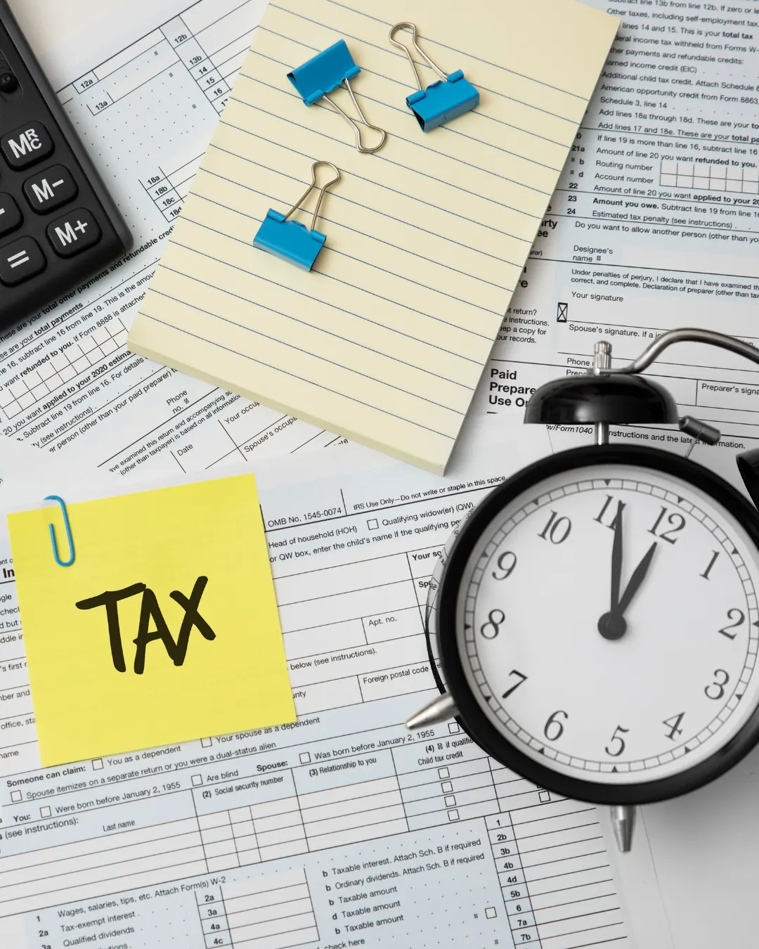 Tax paperwork beside an alarm clock